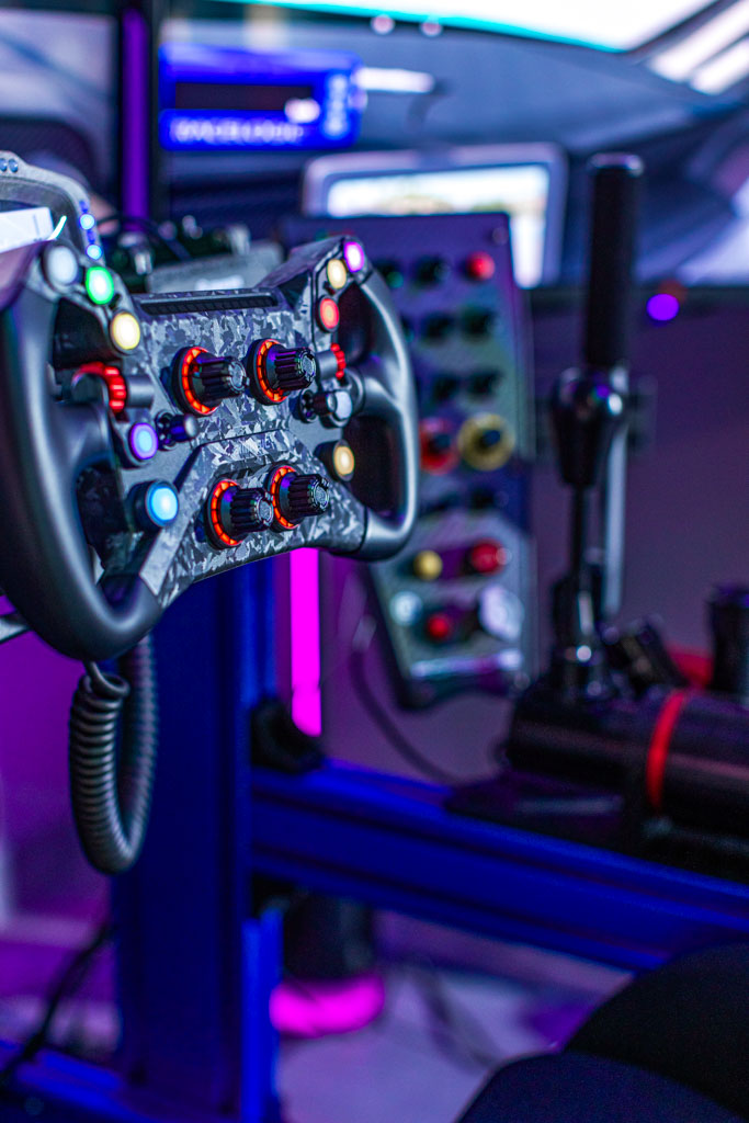 Full-motion racing simulator rig with triple screens in North Miami